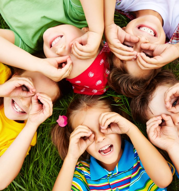 Group of cute children lying on grass