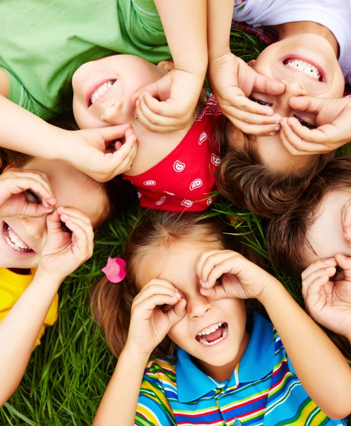 Group of cute children lying on grass