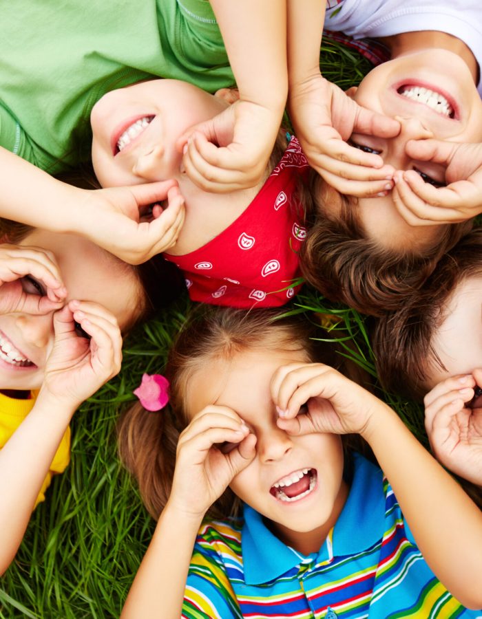 Group of cute children lying on grass