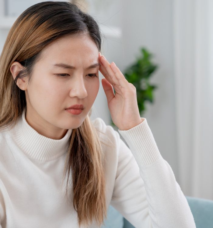 Headache, female having migraine pain, bad health, Asian woman feeling stress and headache, Office syndrome, sad tired touching forehead having migraine or depression, irritated girl, sadness grief