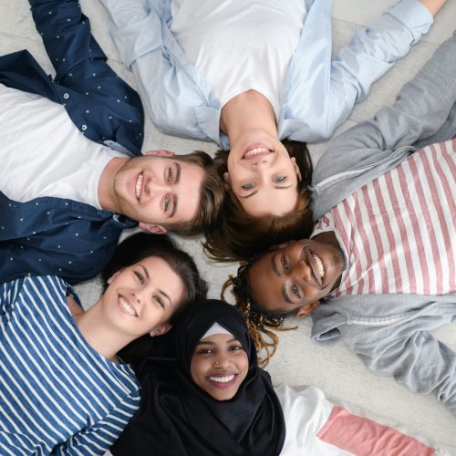 a top view of a diverse group of people lying on the floor and symbolizing togetherness