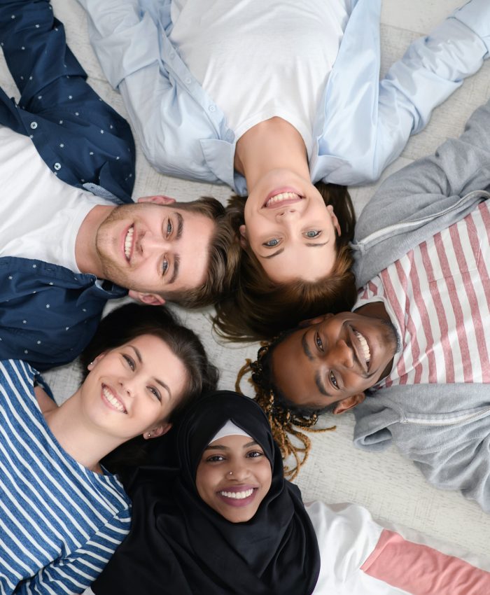 a top view of a diverse group of people lying on the floor and symbolizing togetherness