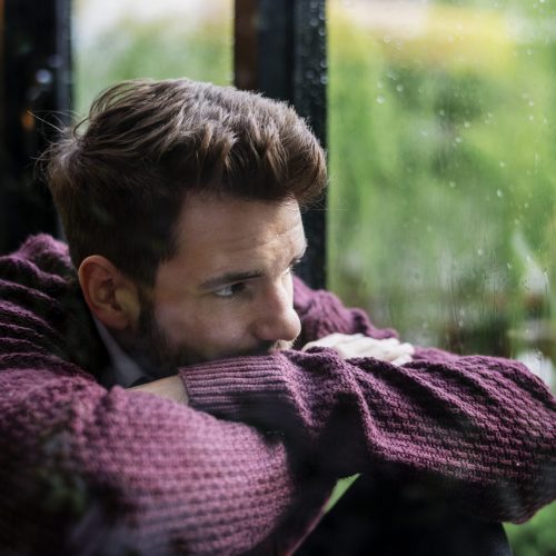 Thoughtful man looking out the window